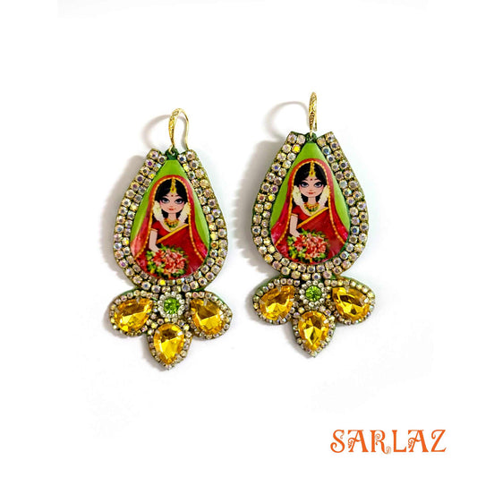 Decorative earrings of an Indian Bride with a colourful design on a white background, featuring the brand 'SARLAZ'.