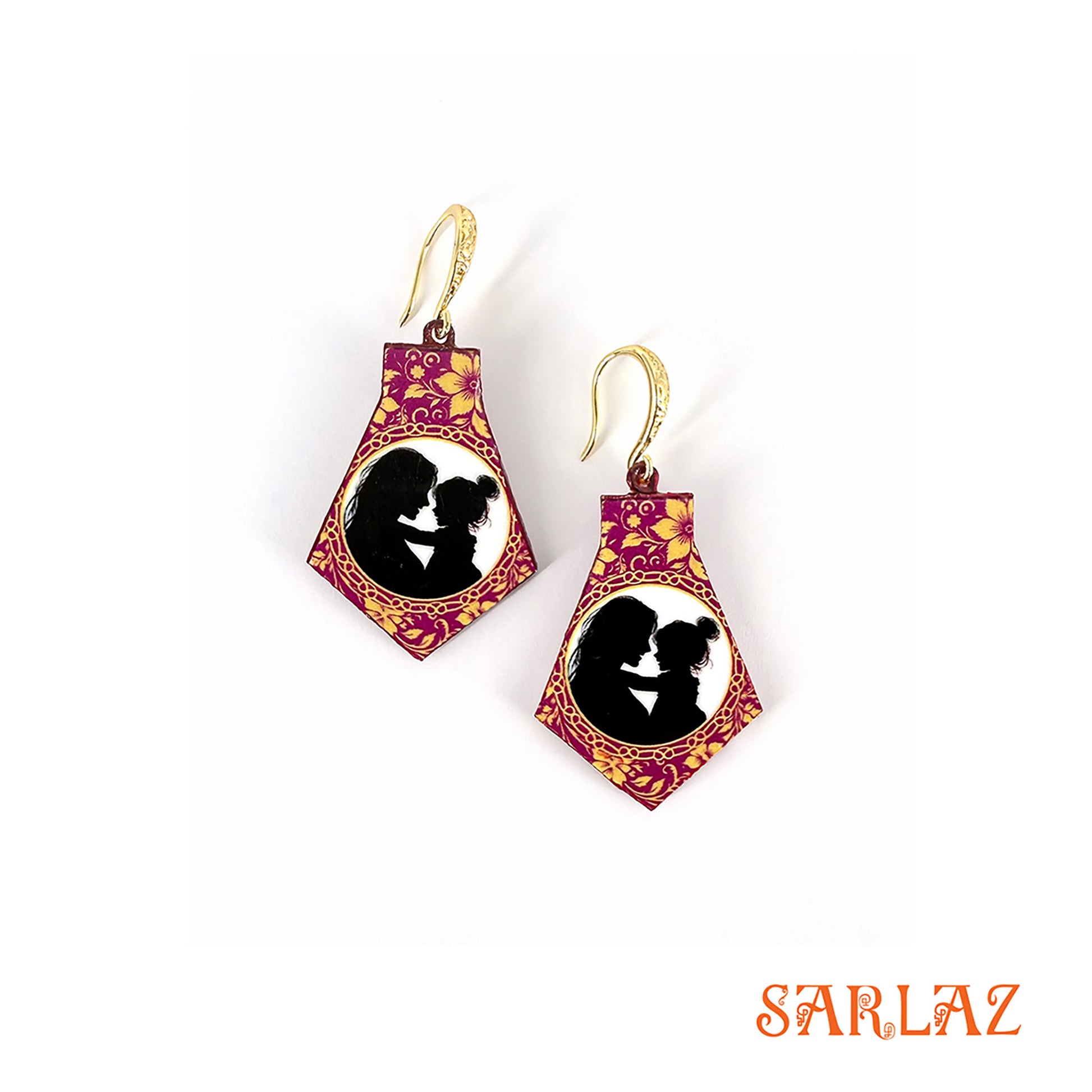 Pair of earrings with a floral design and silhouette of a mother and daughter, branded 'SARLAZ'.