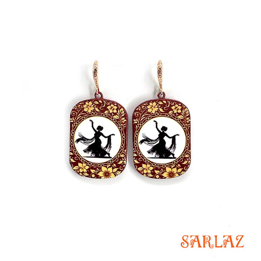 Decorative earrings with floral designs and a silhouette of a dancer on a white background, branded 'SARLAZ'.