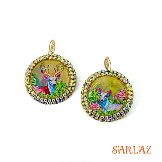 Pair of earrings with deer illustration and rhinestones on a white background, brand 'SARLAZ' visible.