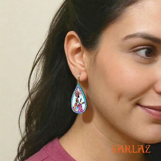 Woman wearing a colorful earring with a neutral background, featuring the brand 'SARLAZ'.