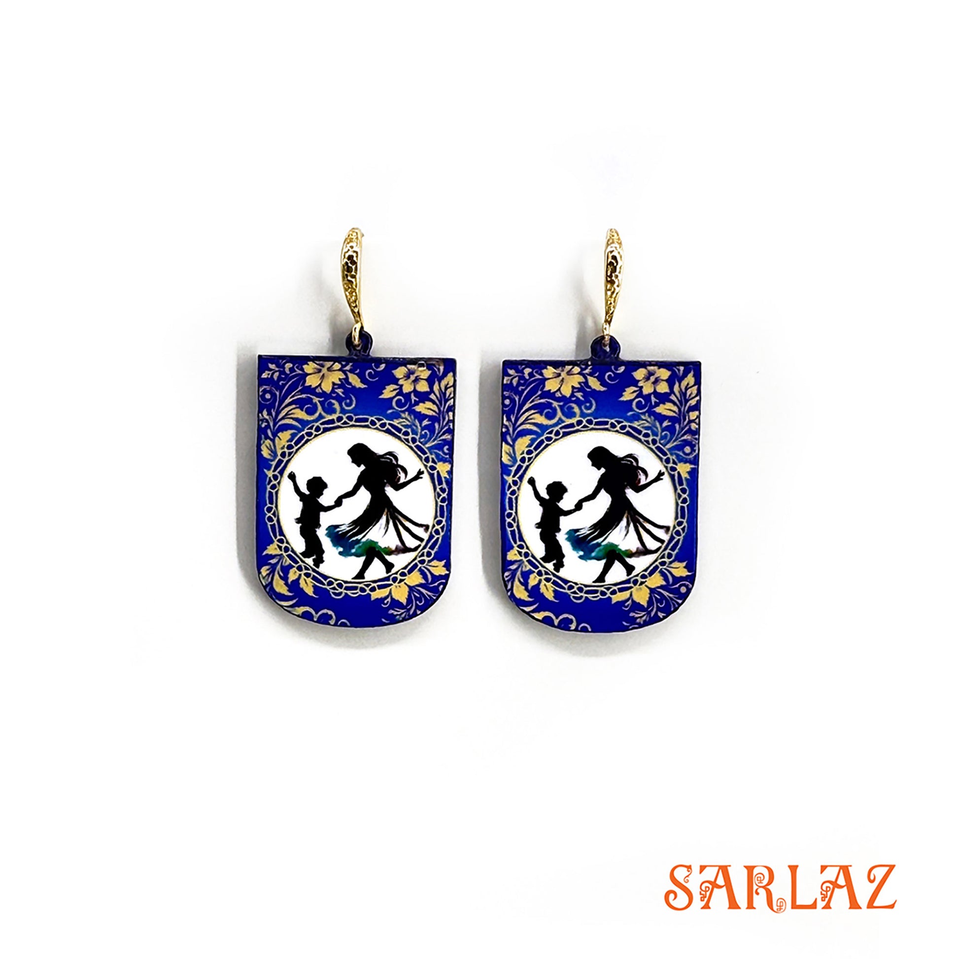 Pair of earrings with blue floral design and silhouette figures of a mother and her son dancing on a white background, branded 'SARLAZ'.