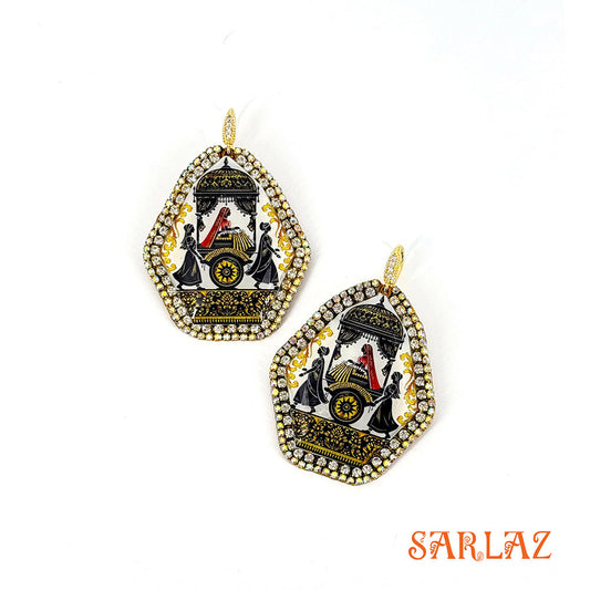 Pair of decorative earrings with art of an Indian Bride convoy, intricate design on a white background, featuring the brand 'SARLAZ'.