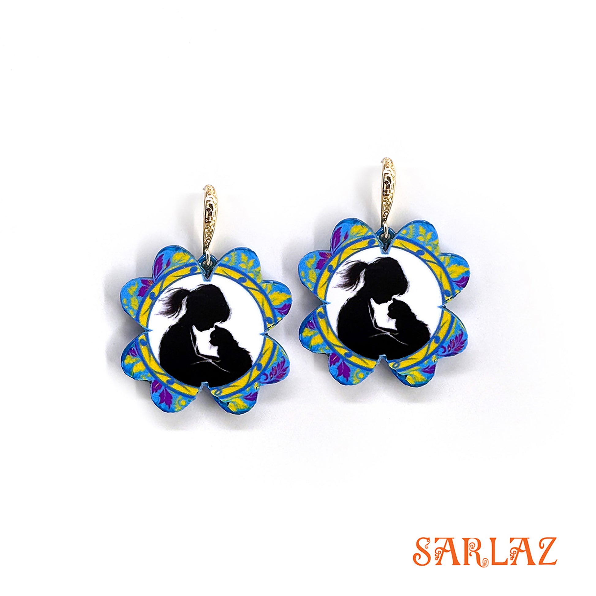 Pair of earrings with floral design and silhouette of a child and kitten, brand 'SARLAZ' visible.