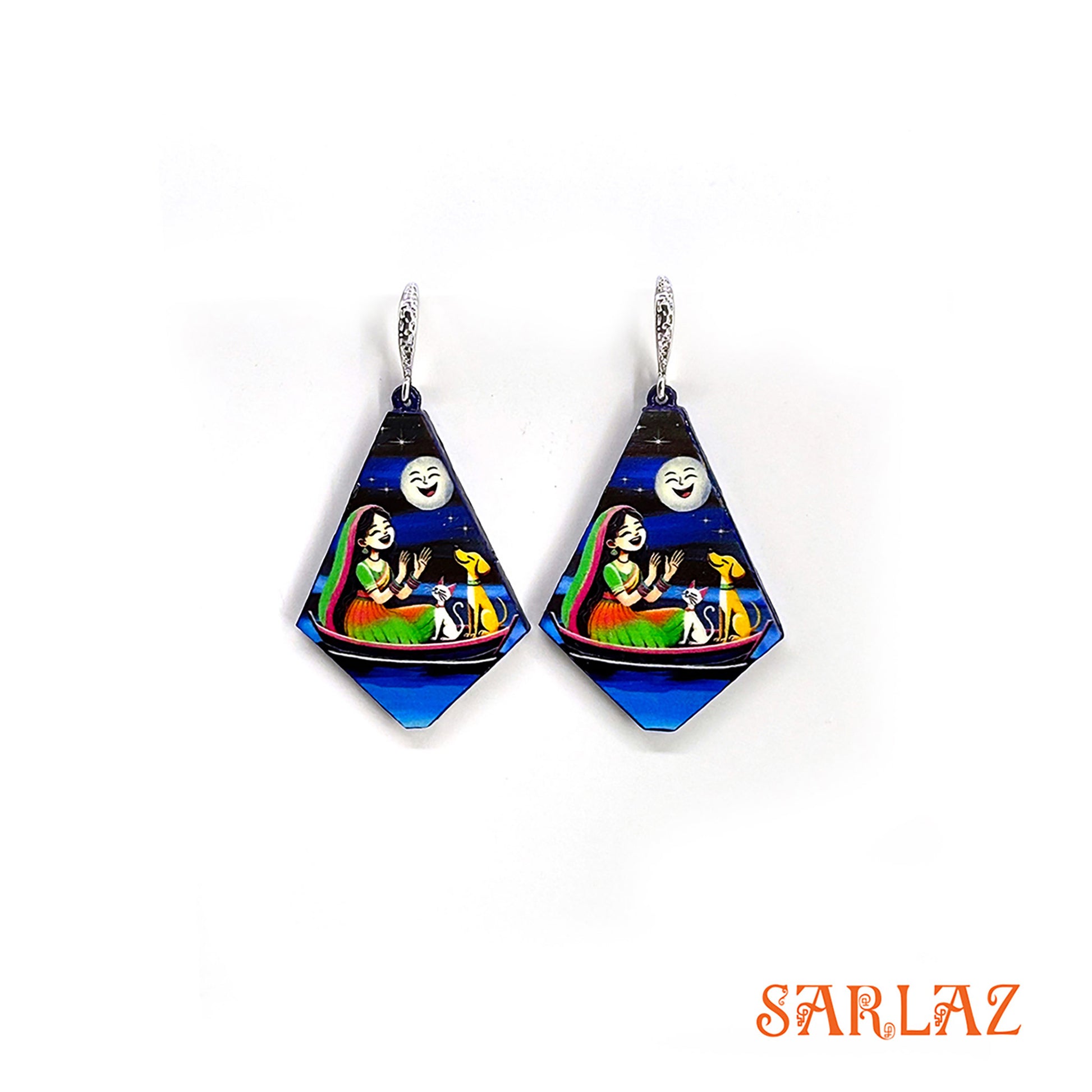 Pair of diamond-shaped earrings with colourful art of a girl, with her cat and dog sitting on a boat, under the moonlit, featuring the brand 'SARLAZ'.