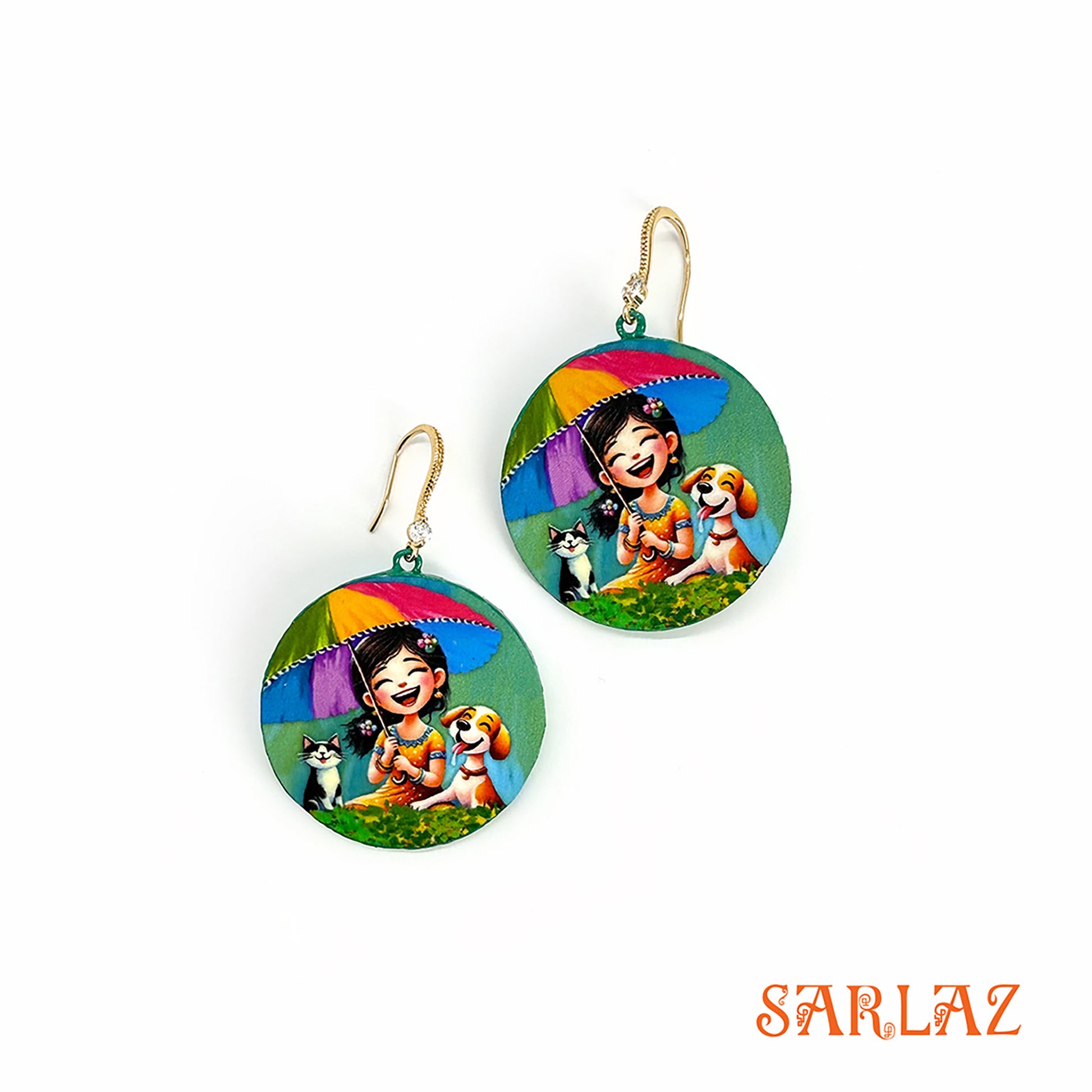 Hand-painted on wood in a circular shape, this vibrant design captures a girl laughing with her dog and cat under a colourful umbrella, featuring the brand 'SARLAZ'.