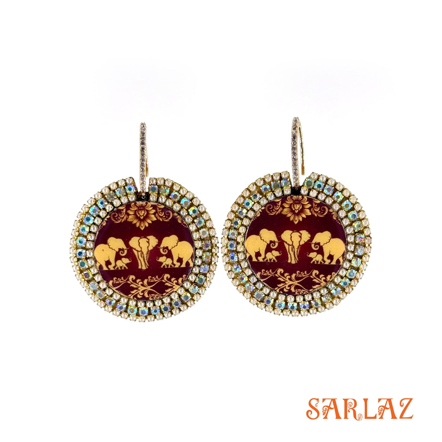 Pair of earrings with elephant family design on maroon pattern background, featuring the brand 'SARLAZ'.