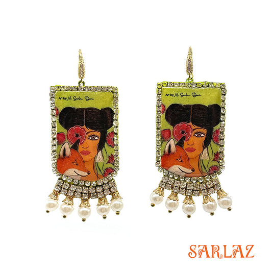 Pair of earrings of a Fox and woman with artistic design and pearl embellishments on a white background, featuring the brand 'SARLAZ'.