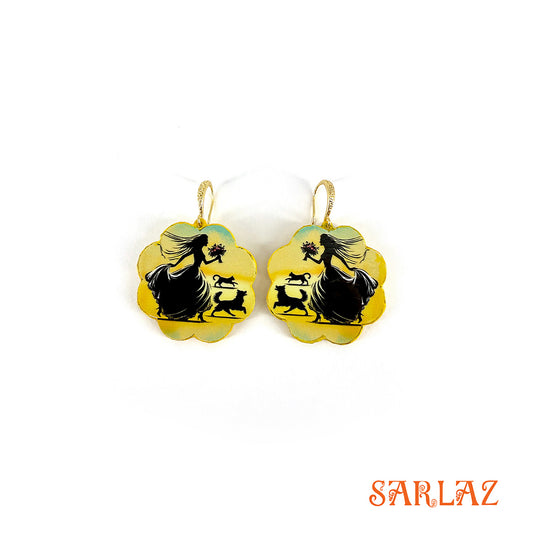 Pair of earrings with silhouettes of a bride with her cat and dog design on a yellow background, branded 'SARLAZ'.