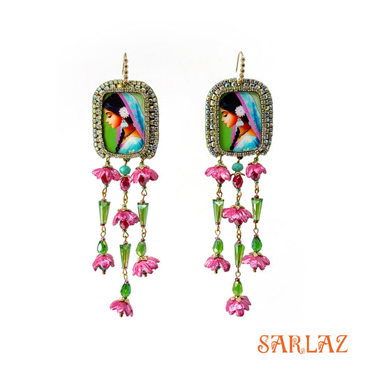 Colourful earrings with a woman portrait and floral designs and  'SARLAZ' brand logo on a white background