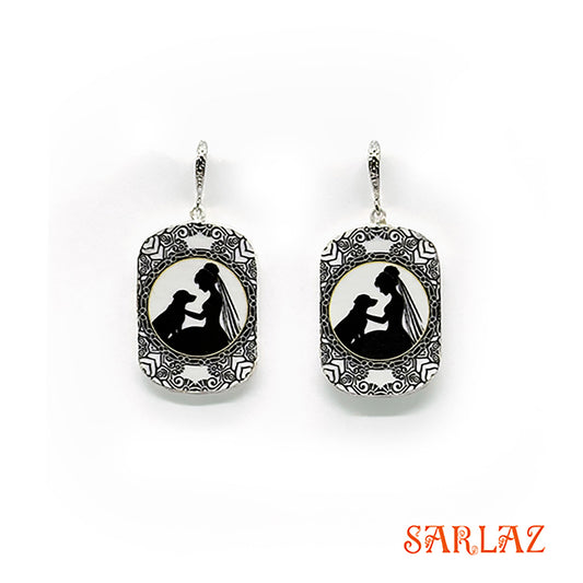 Pair of earrings with a silhouette design of a bride and her dog, branded 'SARLAZ', on a white background.