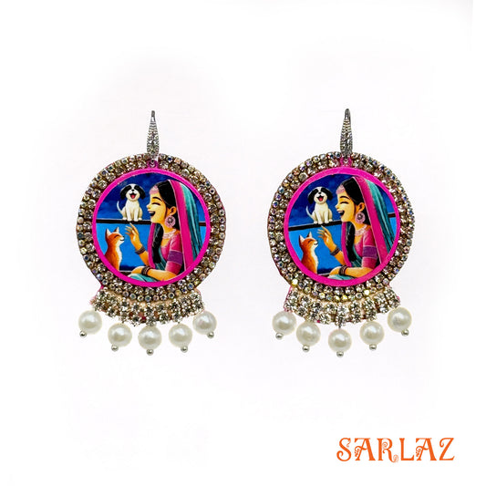 Decorative earrings with a colorful design featuring a woman, dog, and cat, branded 'SARLAZ'.