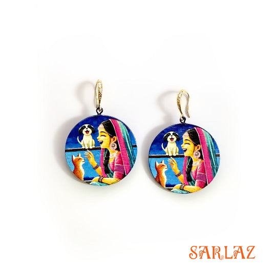 Colorful earrings with a design of a woman, dog, and cat on a white background, branded 'SARLAZ'.