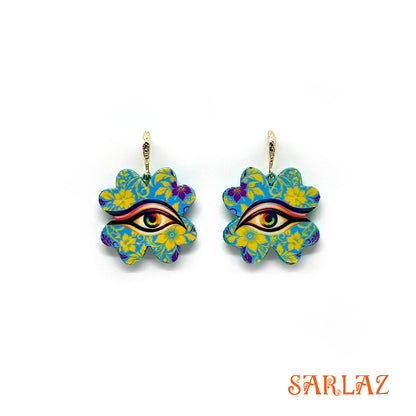 Colorful floral earrings, each four-leaf clover bursts with electric blue and golden yellow, forming patterns that seem to shift and breathe with a life of their own. At the heart rests the ever-watchful eye, framed by petals that radiate both joy and vigilance. 