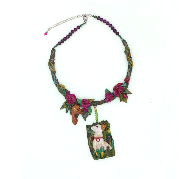 Dog Nature statement necklace, the design on the necklace captures the happy moment of a dog admiring a bird in the garden. A design by SARLAZ